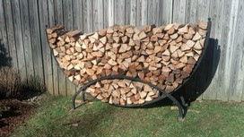 Firewood stacked in half round rack.